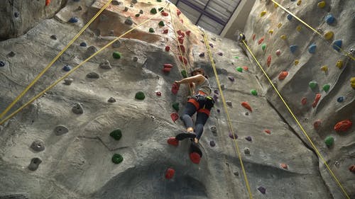 一个女人爬上墙的低角度视图 · 免费素材视频
