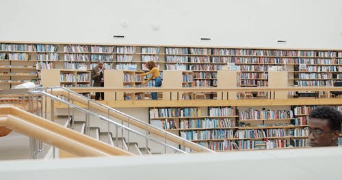 人们在图书馆里寻找书籍 · 免费素材视频