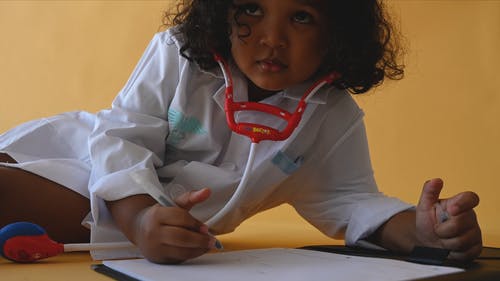 一个穿医生服装的女孩用笔写字 · 免费素材视频