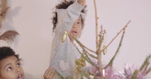 一个小女孩把星星放在圣诞树上 · 免费素材视频