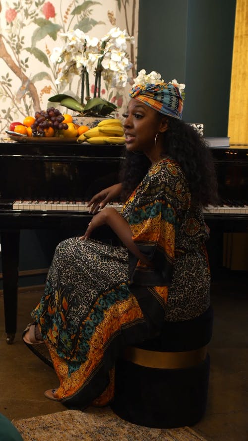 一个女人坐在钢琴旁边 · 免费素材视频