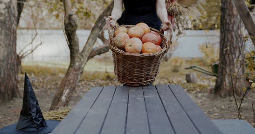 一个女人在桌上倒一篮子万圣节南瓜 · 免费素材视频