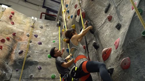 低角度拍摄的一个男人和女人爬上墙 · 免费素材视频