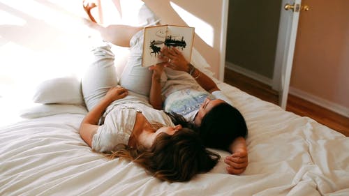 一对夫妇在床上一起读书 · 免费素材视频