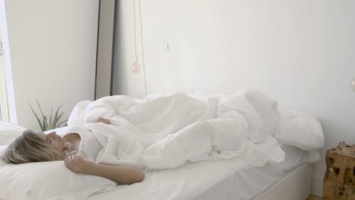 女人在她的床上醒来 · 免费素材视频