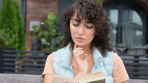 一个女人读一本书的浅焦点 · 免费素材视频