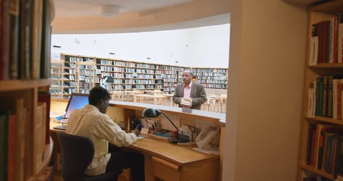 一个男人从图书馆借书 · 免费素材视频
