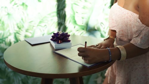 一个女人在卡上写 · 免费素材视频