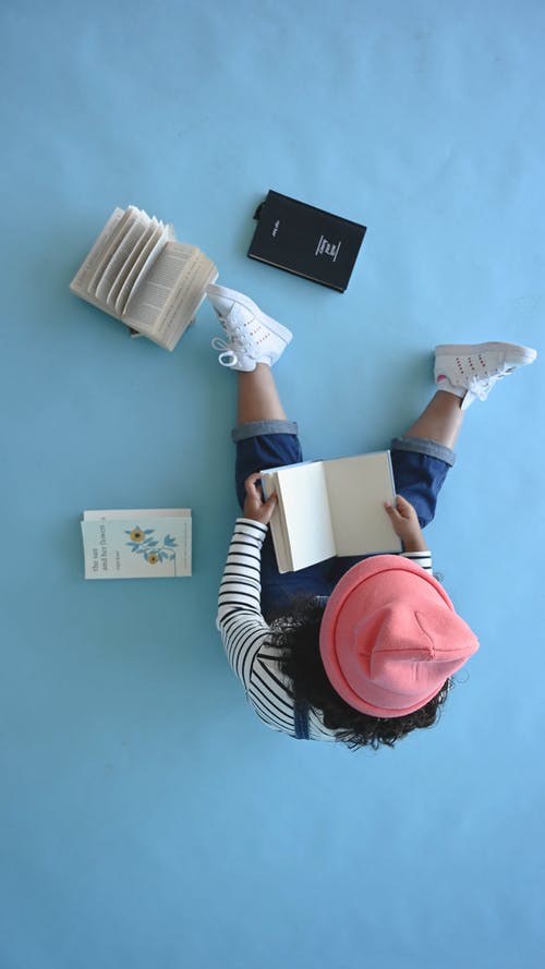 一个孩子坐在地板上看书 · 免费素材视频