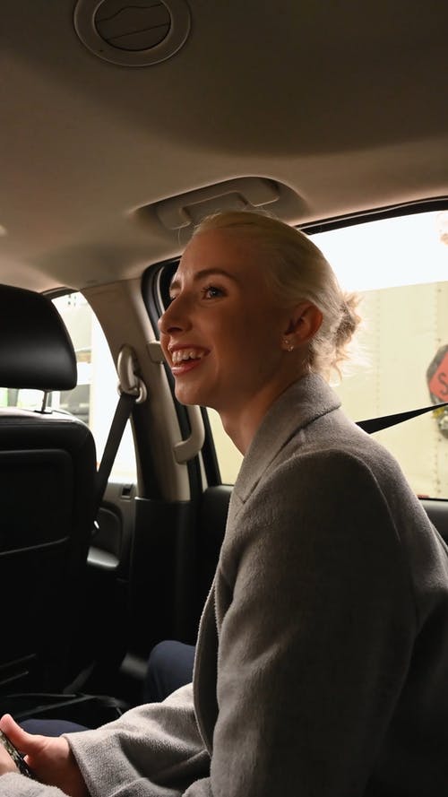 一个女人在车内时使用她的手机 · 免费素材视频