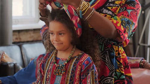 母亲在女儿的头发绑头饰 · 免费素材视频
