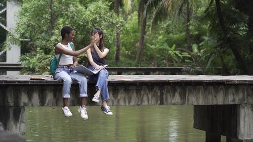 做高五时坐在木板上的两个女人 · 免费素材视频