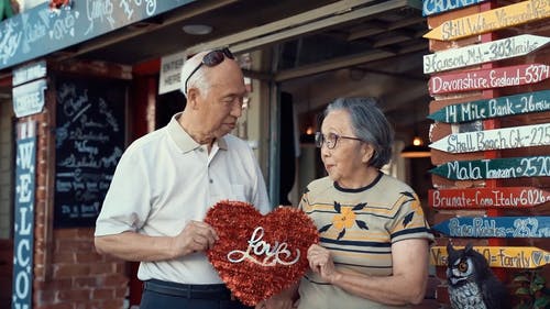 老年夫妇抱着一颗心拍照 · 免费素材视频