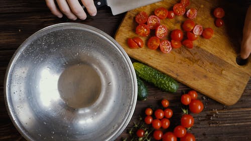 一个人把切好的樱桃西红柿放在碗里 · 免费素材视频