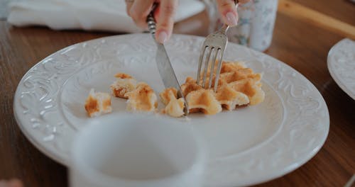 一个人在板上切片华夫饼的特写视图 · 免费素材视频