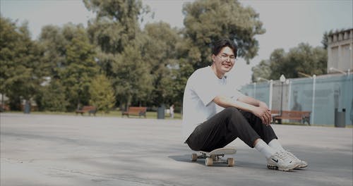 一个男人坐在滑板上 · 免费素材视频