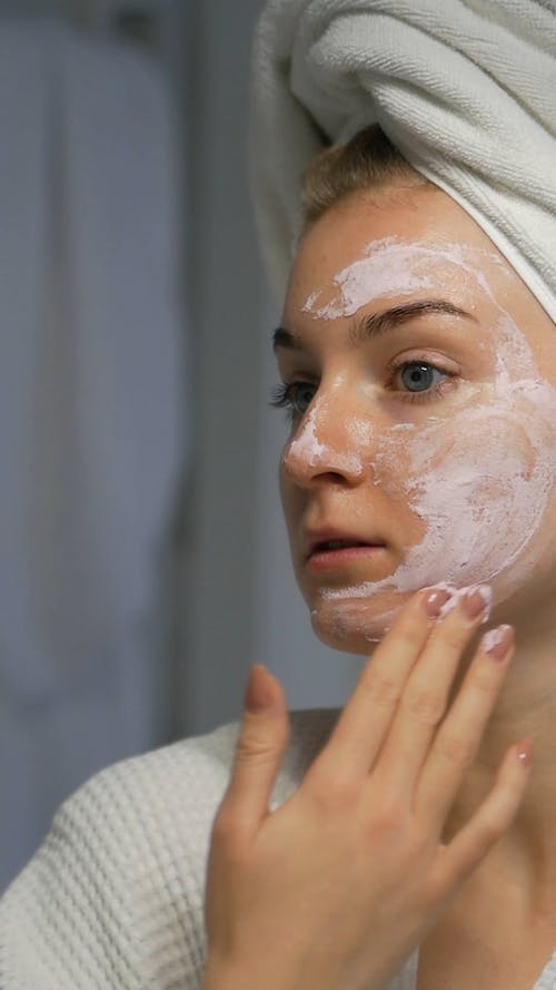 女人在她脸上应用面具的视频 · 免费素材视频