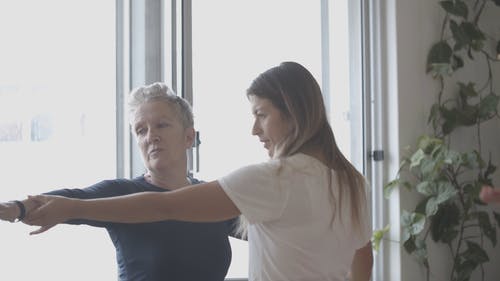 瑜伽教练帮助一个女人做瑜伽 · 免费素材视频