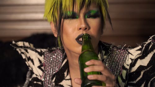 在绿色的瓶子上喝酒的人 · 免费素材视频