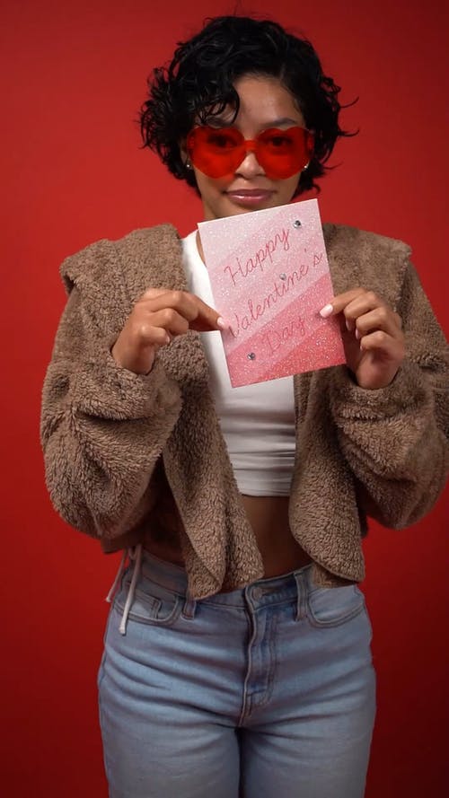 女人微笑着拿着情人节贺卡 · 免费素材视频