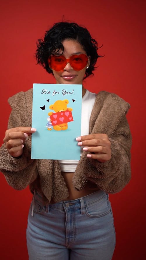 女人微笑着拿着情人节贺卡 · 免费素材视频