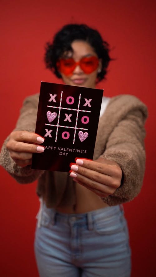 女人微笑着拿着情人节贺卡 · 免费素材视频