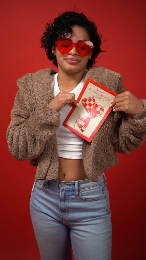 女人微笑着拿着情人节贺卡 · 免费素材视频