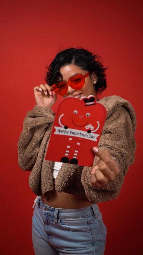 女人微笑着拿着情人节贺卡 · 免费素材视频