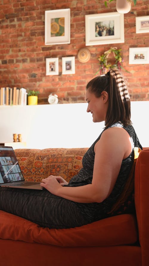 女人坐在沙发上用她的笔记本电脑 · 免费素材视频
