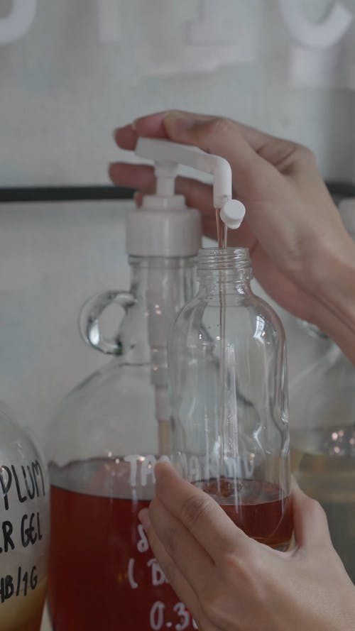在较小的玻璃瓶上泵送液体肥皂 · 免费素材视频
